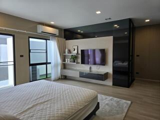 Modern bedroom with large window, air conditioning, and wall-mounted TV