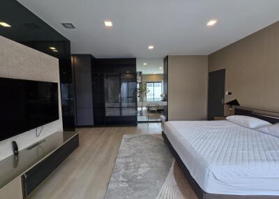 Modern bedroom with large bed and TV