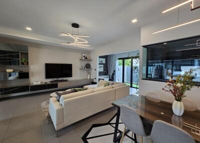 Modern living room and dining area with contemporary lighting and large glass doors