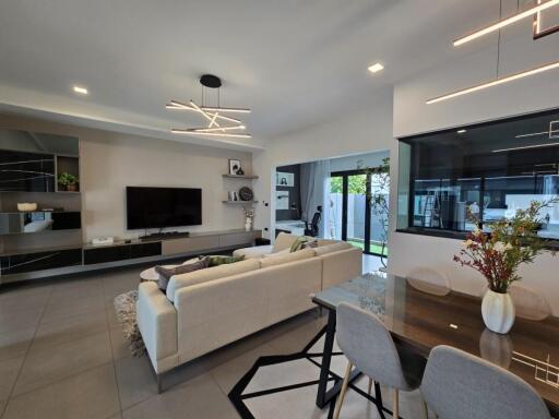 Modern living room and dining area with contemporary lighting and large glass doors