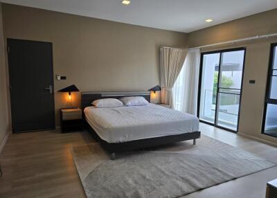 Spacious and modern bedroom with large windows and balcony