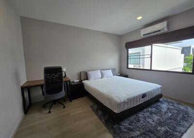 spacious bedroom with a double bed and work area