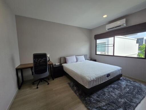 spacious bedroom with a double bed and work area