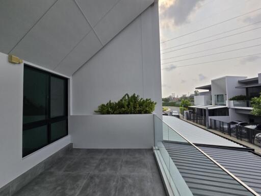 Spacious balcony with modern design and glass railing