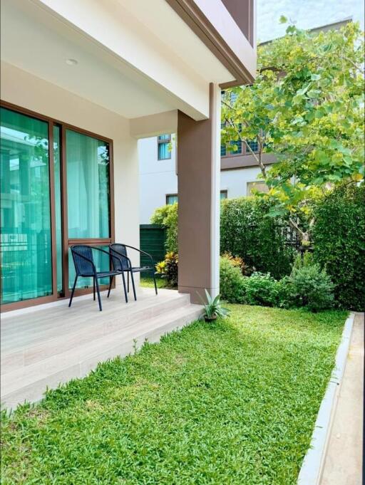 Outdoor patio with chairs and greenery