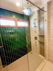 Modern bathroom with glass shower and green tiles