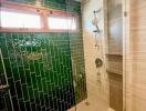 Modern bathroom with glass shower and green tiles