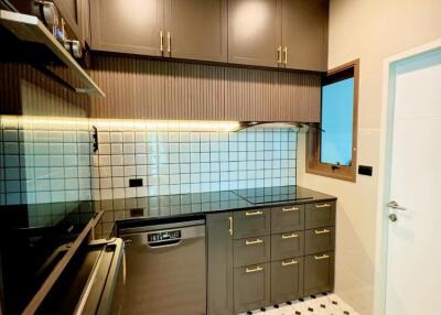 Modern kitchen with dark cabinets and tiled backsplash