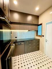 Modern kitchen with dark cabinets and tiled backsplash