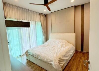 Modern bedroom with wooden flooring and ceiling fan