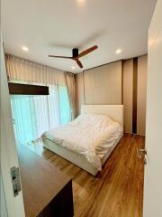 Modern bedroom with wooden flooring and ceiling fan