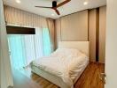 Modern bedroom with wooden flooring and ceiling fan