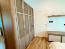 Bedroom with large wardrobe and wooden floor