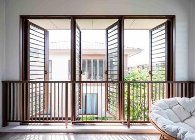 Balcony with wooden railing and open windows