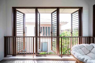 Balcony with wooden railing and open windows