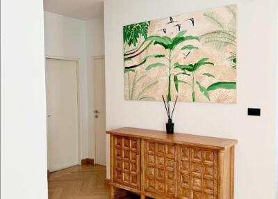 modern hallway with wooden cabinet and botanical wall art