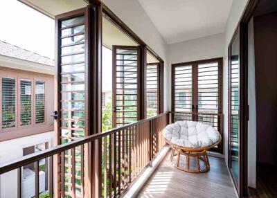 Well-lit balcony with large windows and a cozy chair