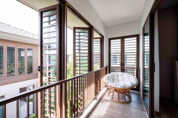 Well-lit balcony with large windows and a cozy chair