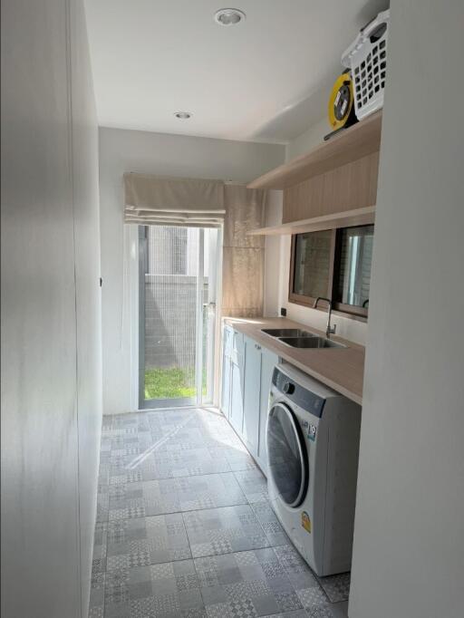 Modern laundry room with washer and storage