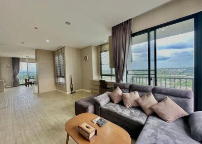 Spacious living room with large windows and comfortable seating