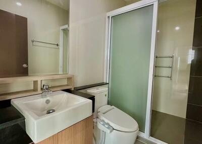 Modern bathroom with sink, toilet, and shower enclosure