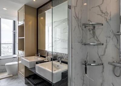 Modern bathroom with dual sinks, large mirrors, and a walk-in shower