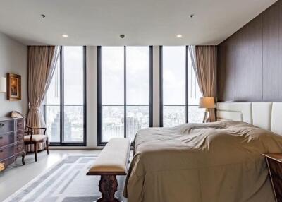 Spacious bedroom with large windows and city view