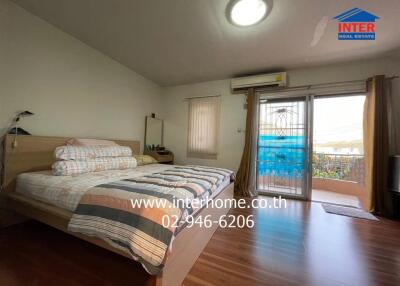 Spacious bedroom with bed, window, air conditioner, and balcony access