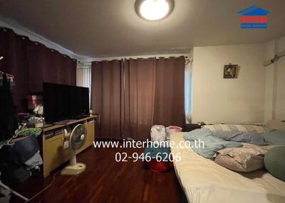 Bedroom with a bed, curtains, and a TV