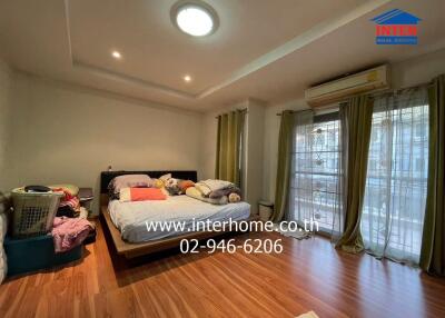 Spacious bedroom with wooden flooring and balcony access