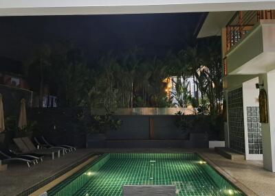 Night view of a poolside area with lounge chairs