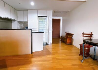 Modern kitchen with open fridge and wooden flooring