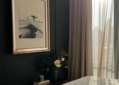 Cozy bedroom with a framed picture, bedside table, and natural light