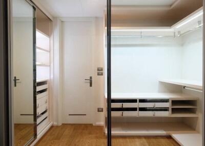 Modern walk-in closet with wooden flooring