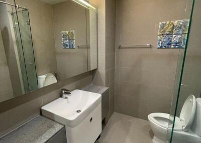 Modern bathroom with vanity sink, mirror, and toilet