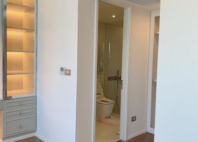 Hallway with built-in shelves leading to bathroom