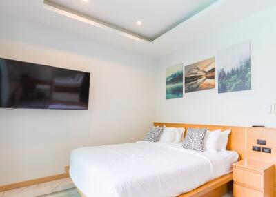 Modern bedroom with wall-mounted TV and artwork