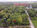 Aerial view of a plot of land surrounded by lush greenery