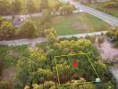 Aerial view of a plot of land with surrounding trees and roads