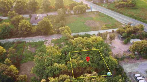 Aerial view of a plot of land with surrounding trees and roads