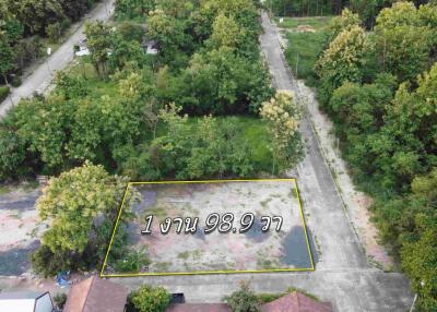 Aerial view of an empty land plot surrounded by trees.