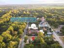 Aerial view of a property surrounded by trees with a nearby statue and marked plot