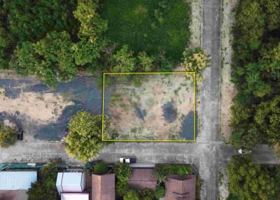 Aerial view of a plot of empty land surrounded by greenery