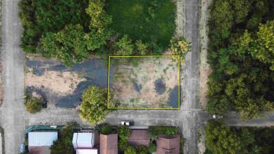 Aerial view of a plot of empty land surrounded by greenery