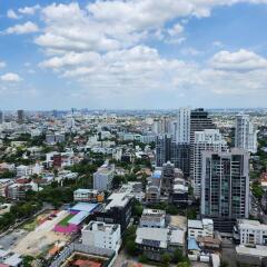 Aerial view of urban cityscape with high-rise buildings and cloudy sky