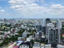 Aerial view of urban cityscape with high-rise buildings and cloudy sky