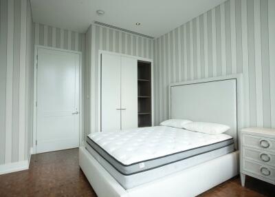 Modern bedroom with white furniture and striped wallpaper