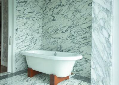 Modern bathroom with freestanding bathtub and marble walls