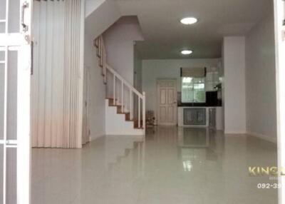 Spacious modern living area with tiled flooring and adjacent kitchen