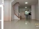 Spacious modern living area with tiled flooring and adjacent kitchen